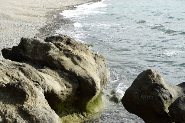 istock seawaves pounding rock formation on ocean waterfront 1196785954