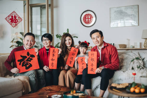 Three generations of joyful Asian family holding Chinese Fai Chun (Auspicious Message) and celebrating Chinese New Year together Three generations of joyful Asian family holding Chinese Fai Chun (Auspicious Message) and celebrating Chinese New Year together china chinese ethnicity smiling grandparent stock pictures, royalty-free photos & images