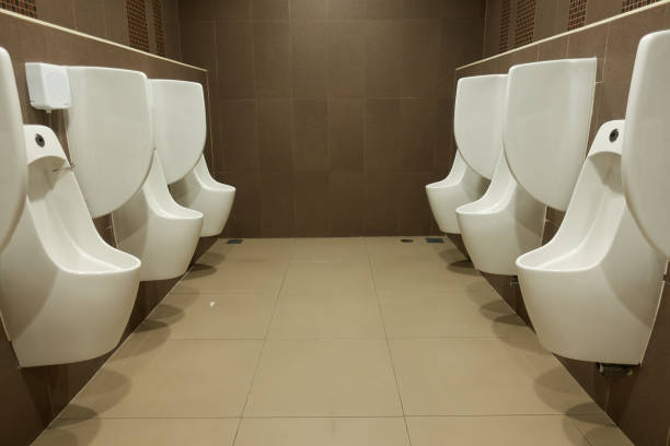 urinaux dans les toilettes des hommes. - urinal public restroom male toilet in a row photos et images de collection