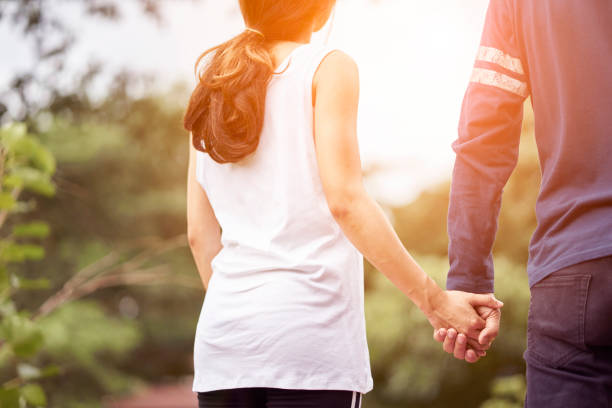 istock Couples holding hands in the park with the sun light. 1196787528