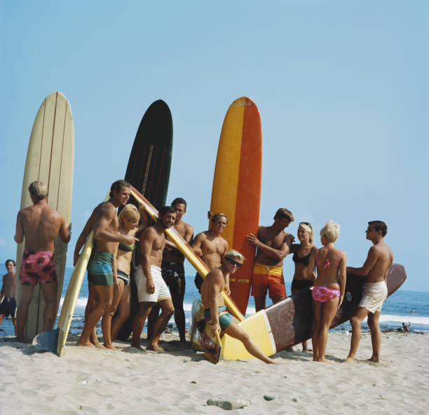 personnes sur la plage avec planche de surf - women sarong beach white photos et images de collection