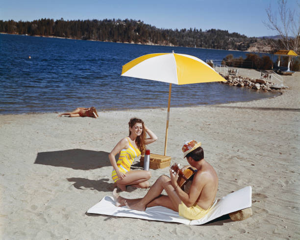 Man playing guitar while woman dancing at beach  1968 stock pictures, royalty-free photos & images