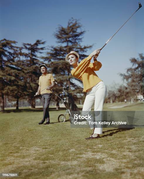 Mujeres Jóvenes Jugando Golf Mientras Que Hombre Parado En El Fondo Foto de stock y más banco de imágenes de De Archivo