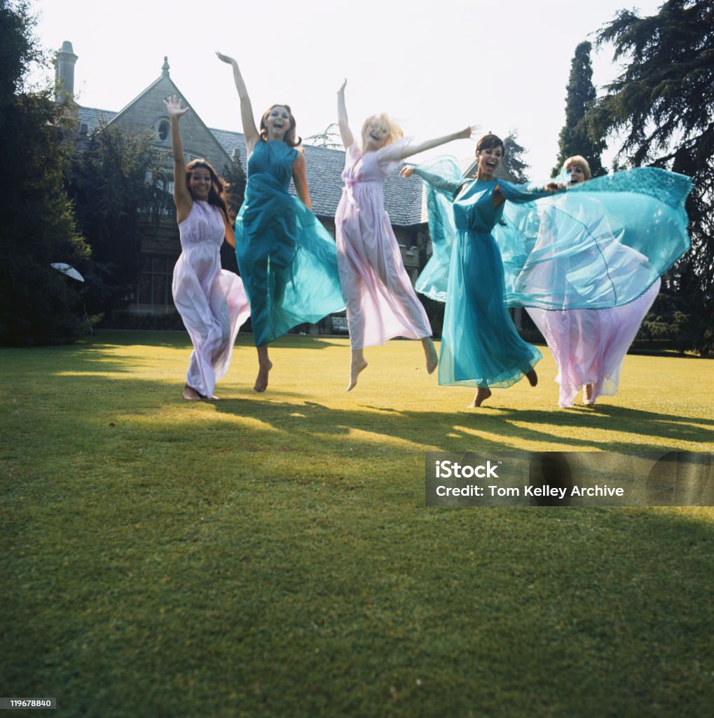 Women jumping on lawn  Five People Stock Photo