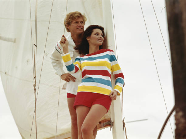 Young couple leaning against sail  sailboat photos stock pictures, royalty-free photos & images