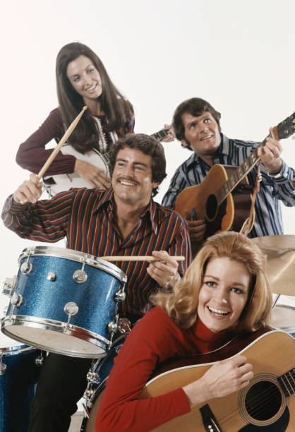 Men and women playing guitar and drum, smiling  1971 stock pictures, royalty-free photos & images