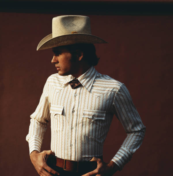 Young man wearing cowboy hat against brown background, close-up  1971 stock pictures, royalty-free photos & images