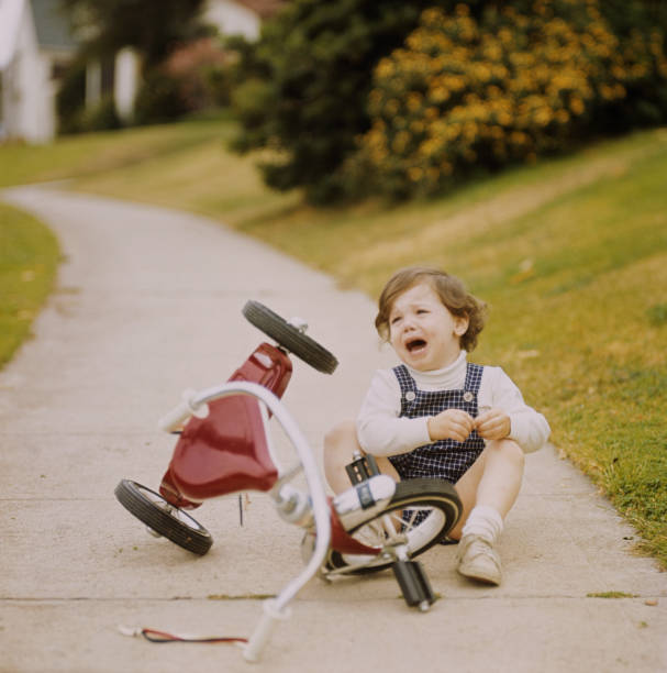 Girl crying next to tricycle  1971 stock pictures, royalty-free photos & images