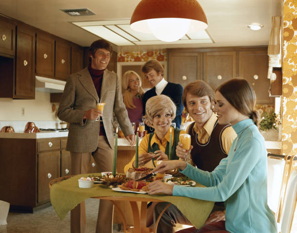 Friends enjoying food party in kitchen  1970s woman stock pictures, royalty-free photos & images