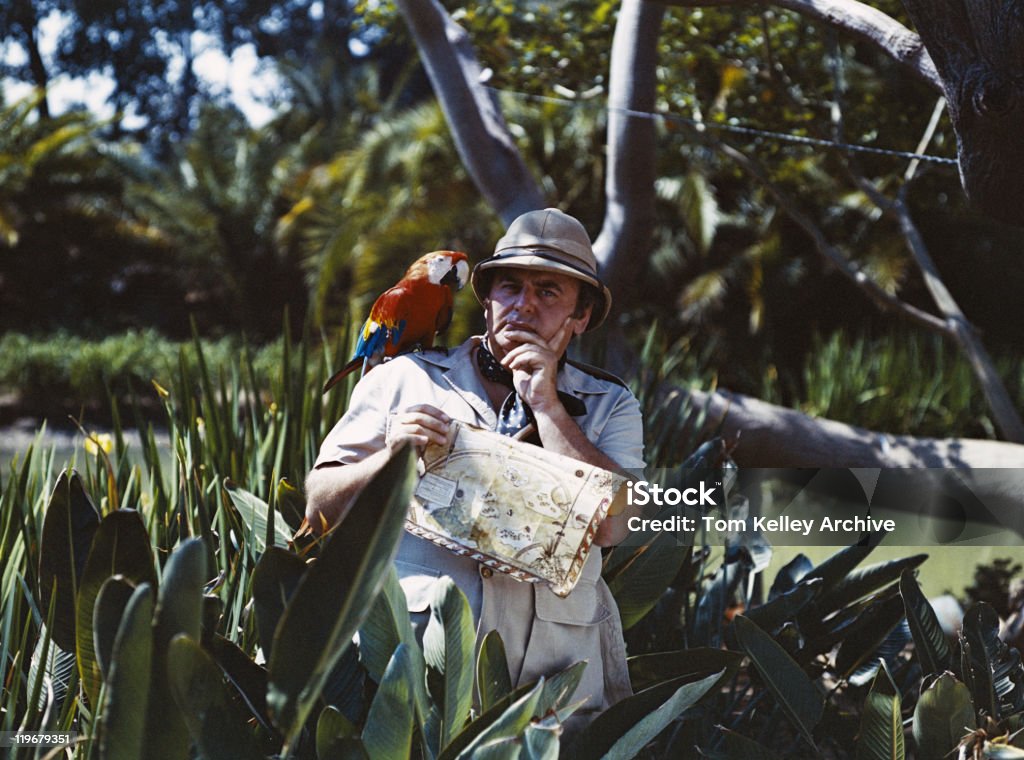 Przewodnik człowiek gospodarstwa mapę z Papuga na ramieniu - Zbiór zdjęć royalty-free (Archiwalny)