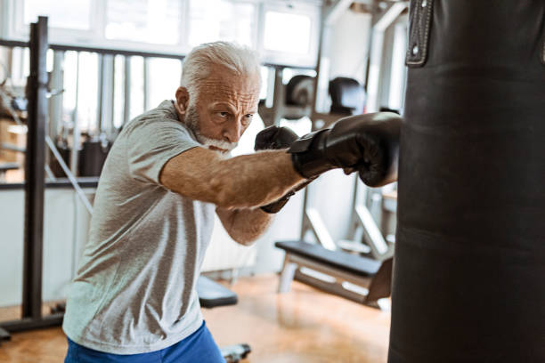 Senior in gym training boxing Senior in gym boxing old man boxing stock pictures, royalty-free photos & images