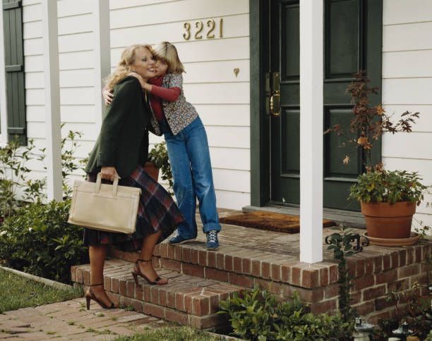 filha beijando a mãe na porta - house kissing women residential structure - fotografias e filmes do acervo