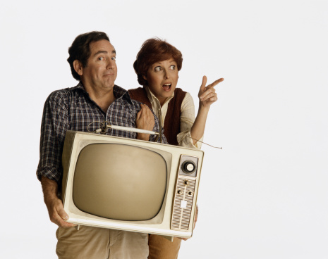 Couple with facial expression holding old television