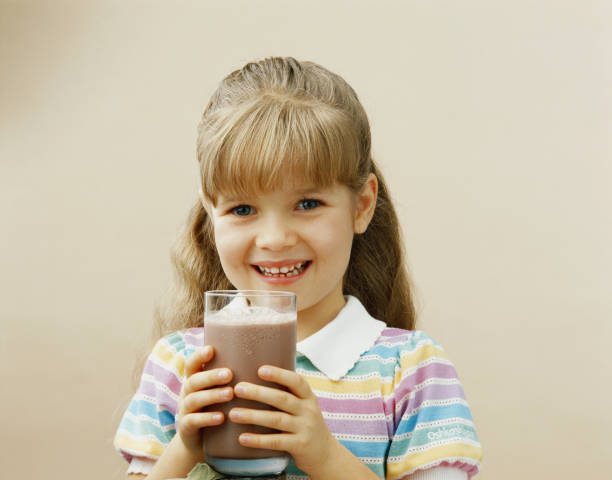 ガラスを抱える少女のミルクセーキ、笑顔、ポートレート - 1985 ストックフォトと画像