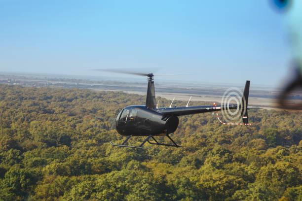 istock Pilot flying a helicopter above the treetops 1196801295