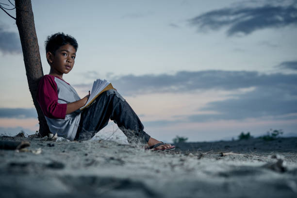 istock Schoolboy studying hard at night under the moonlight 1196803174