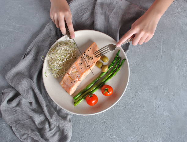 istock Baked salmon steak with basil and vegetables with a fork and a knife on it. 1196803973