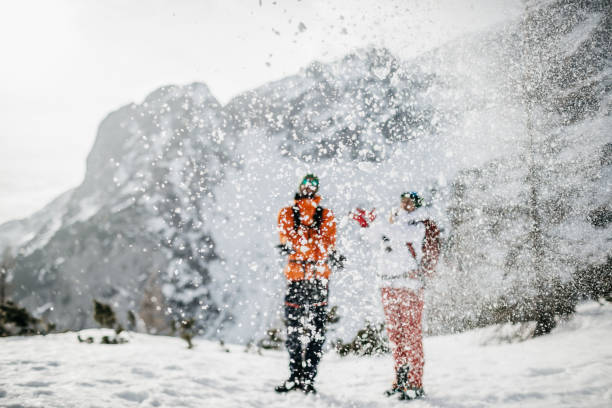 istock Young couple throwing snow in the air 1196808519