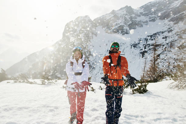 istock Playful young couple throwing snow in the air 1196808741