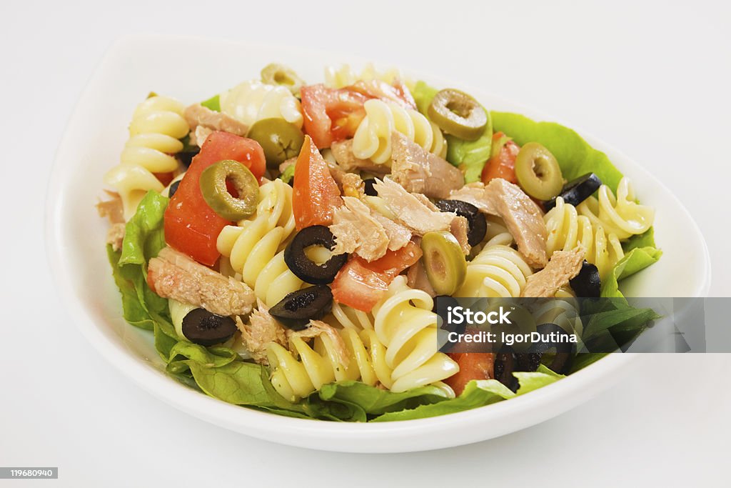 Plate with tuna, pasta, tomato, lettuce and olive salad Tuna and pasta salad with lettuce, tomato and olives Green Olive Fruit Stock Photo