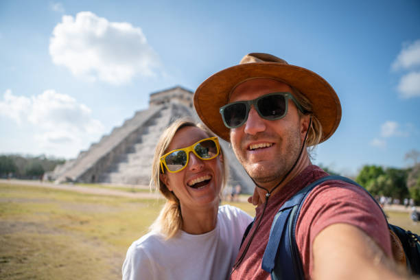 giovane coppia che scatta un ritratto selfie di fronte all'antico tempio maya in messico divertendosi ad esplorare durante le vacanze - mayan temple old ruin ancient foto e immagini stock