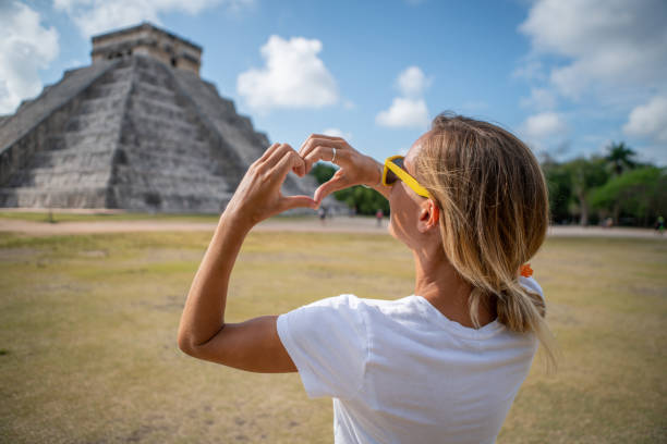 istock Young woman making heart shape on Chichen Itza pyramid, Mexico 1196810651