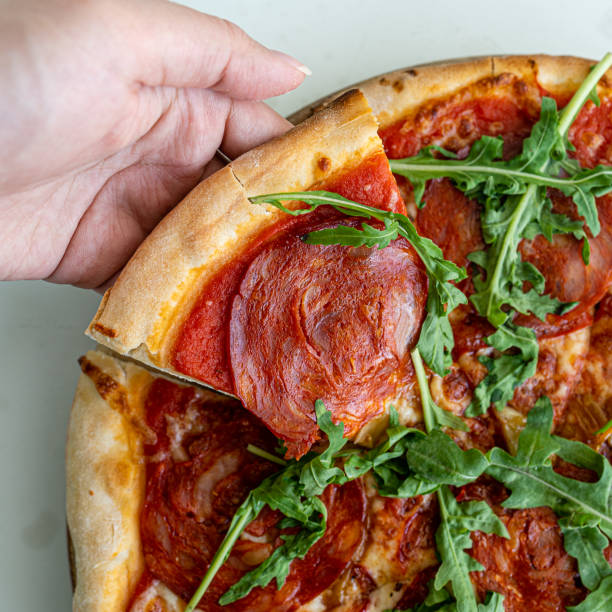 istock Closeup pepperoni pizza on the white table 1196814403