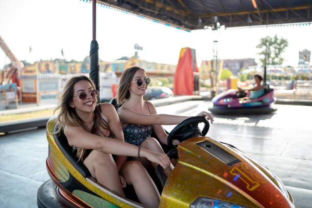 istock Happy girlfriends driving a bumper car and smiling 1196815318