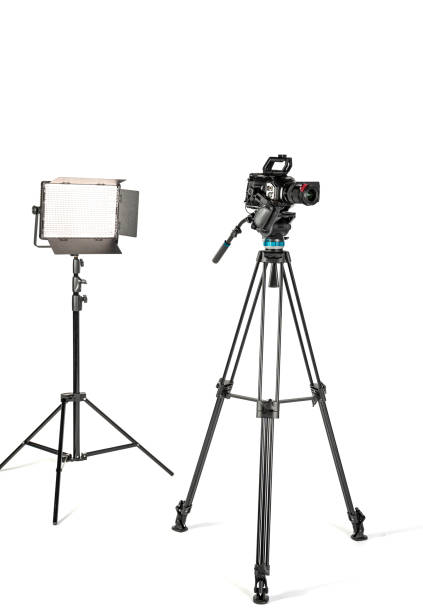 professional video cinema camera on a camera tripod and professional lighting fixture on white studio background - television camera tripod media equipment videography imagens e fotografias de stock