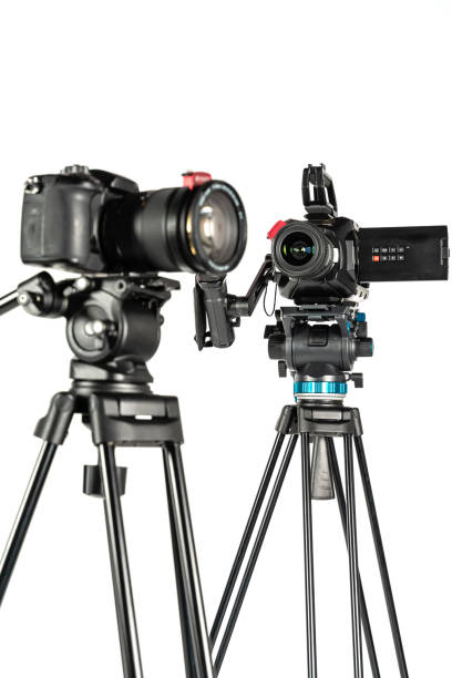 istock Cinema video camera and DSLR mirrorless camera on tripods on white studio background vertical 1196815978