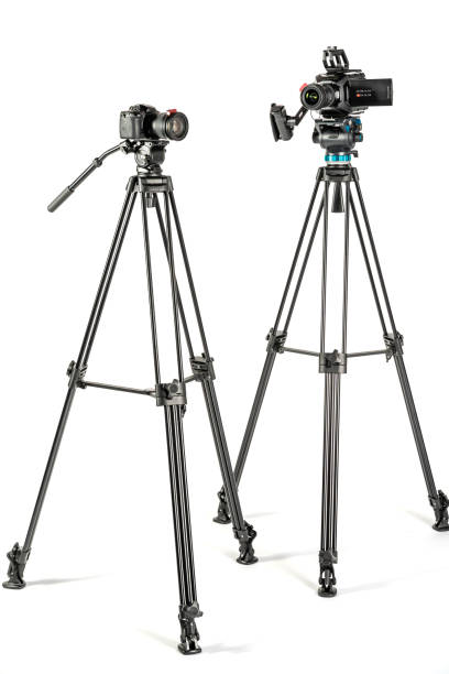 istock Cinema video camera and DSLR mirrorless camera on tripods on white studio background 1196816122