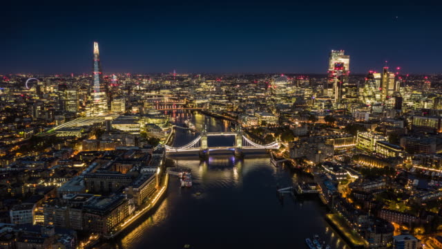 Aerial hyperlapse shot of downtown London at dawn. Thames river with famous Tower Bridge in the foreground. Skyscrapers of the financial district in the background. London, England, UK.
