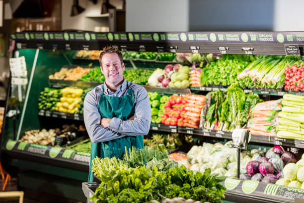 istock Man working in supermarket produce aisle 1196817677