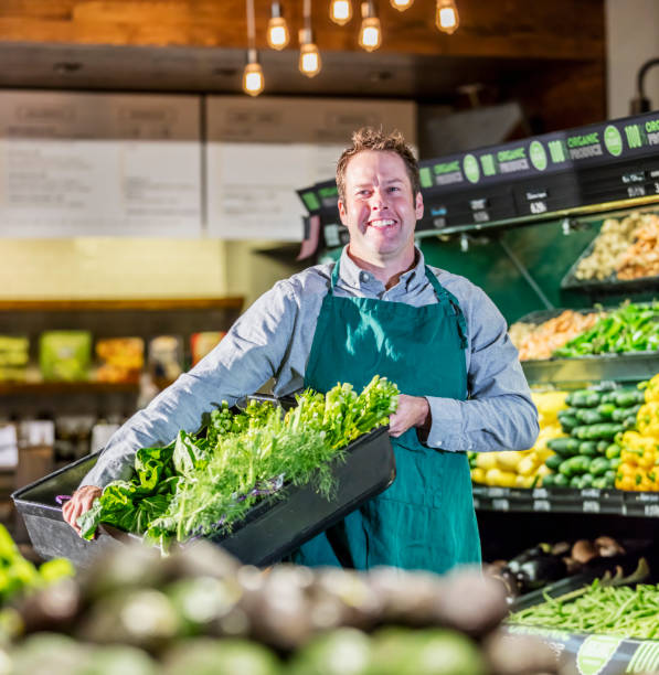 istock Man working in supermarket produce aisle 1196817719