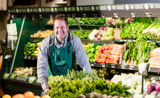 istock Man working in supermarket produce aisle 1196817919