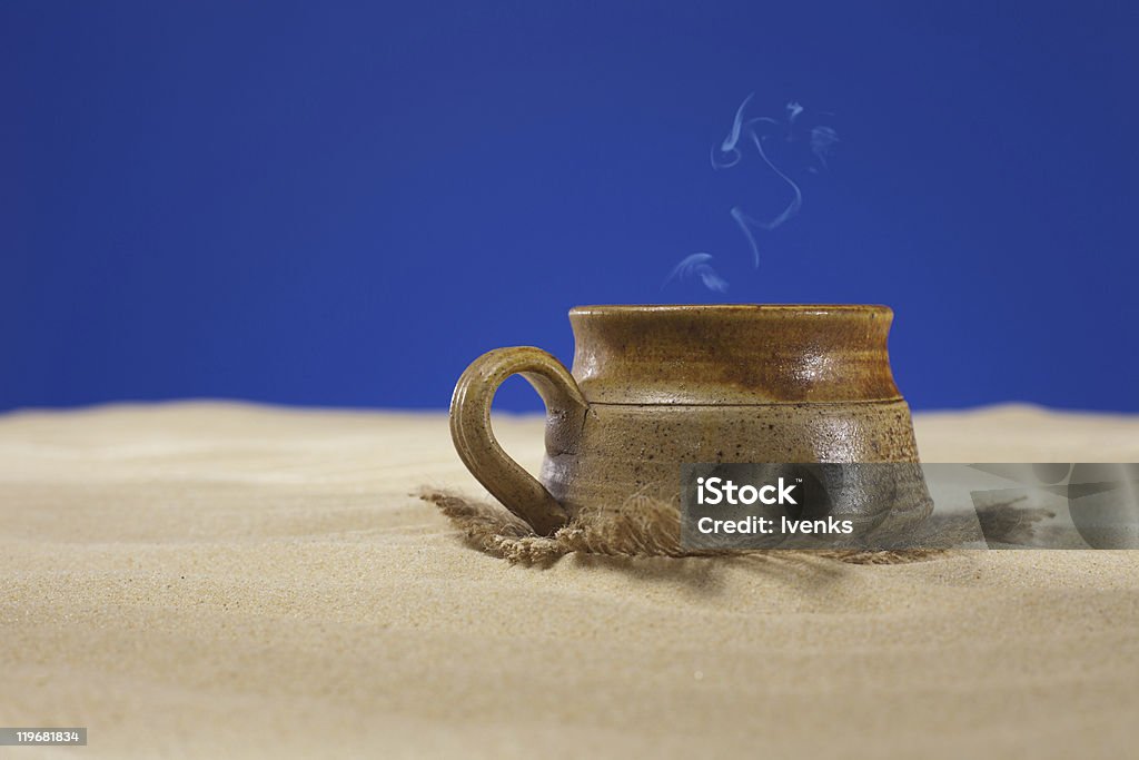 clay tazza di tè o caffè sulla spiaggia di sabbia - Foto stock royalty-free di Argilla