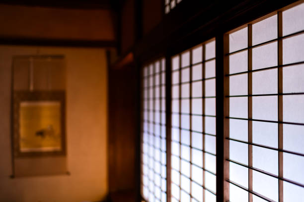 White shoji sliding paper doors closed in traditional japanese house or ryokan pattern and blurry background of tokonoma scroll White shoji sliding paper doors closed in traditional japanese house or ryokan pattern and blurry background of tokonoma scroll alcove stock pictures, royalty-free photos & images