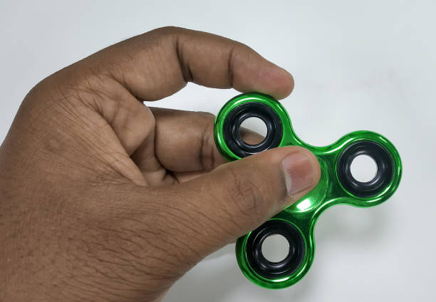istock Green metallic Fidget spinner in hand 1196820497