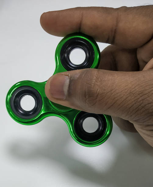 istock Green metallic Fidget spinner in hand 1196820507