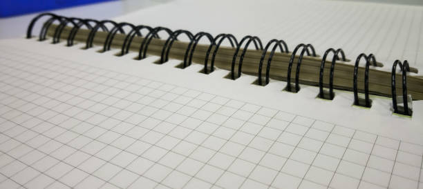 チェックされたパターン紙と付箋とペンを持つスパイラルノートブック - graph paper mesh paper book ストックフォトと画像