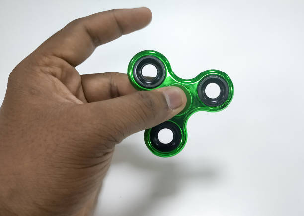 istock Green metallic Fidget spinner in hand 1196820656