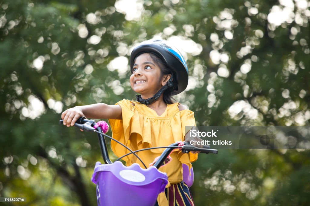 Carefree girl riding bicycle at park Cycling Stock Photo