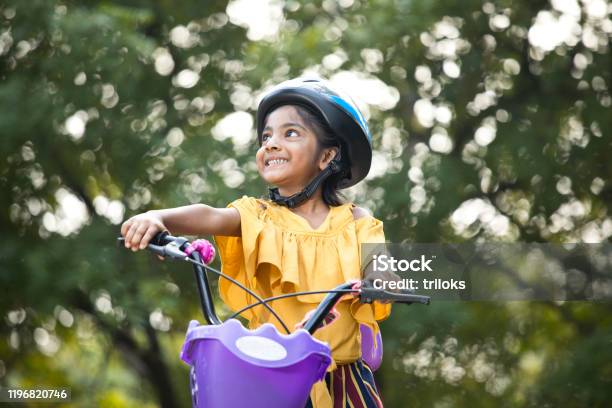 Carefree Girl Riding Bicycle At Park Stock Photo - Download Image Now - Cycling, Child, Bicycle