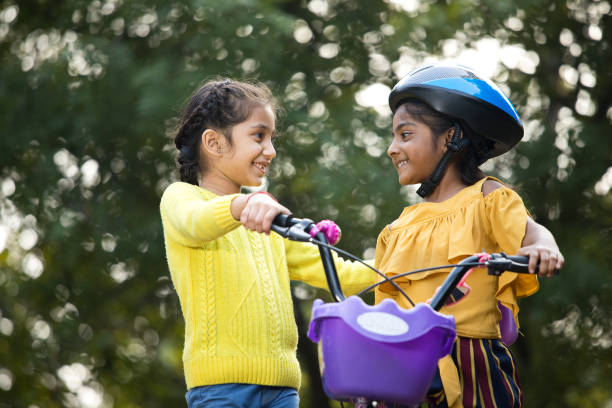 istock Carefree sisters riding bicycle at park 1196821525