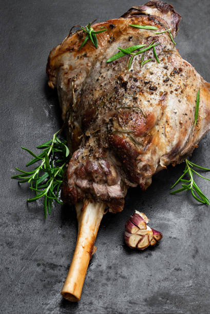 istock Whole roast lamb leg on black stone background 1196823192