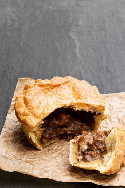 istock Puff pastry steak pie on baking paper on black stone backgroung 1196823226