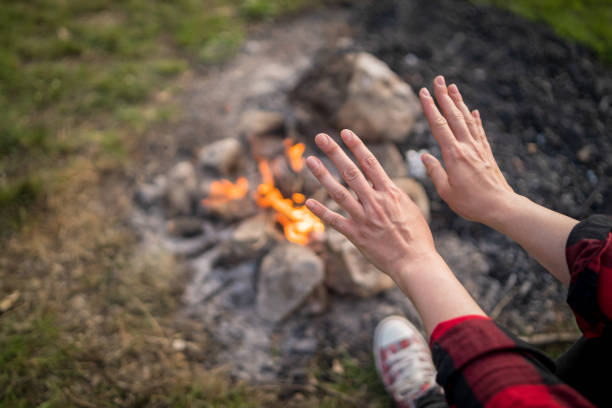 Girl sitting at warm camp fire