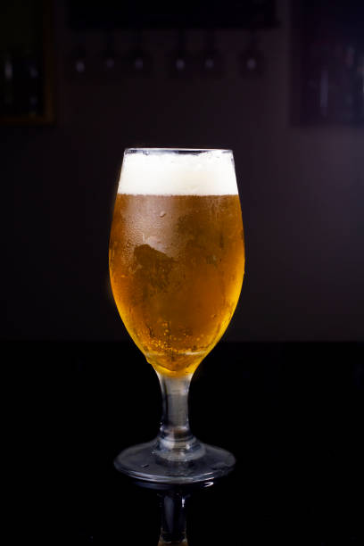 bicchiere pieno di birra, con chopp pilsen su sfondo scuro in un pub - cup of beer foto e immagini stock