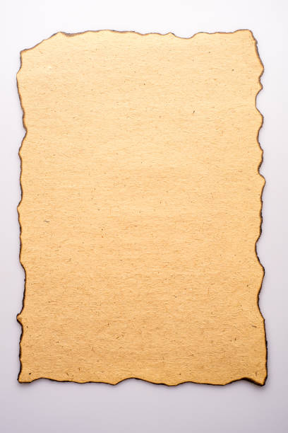 Aged and stained paper with fire damaged and burned edges. Aged and stained paper with fire damaged and burned edges on white background at the edge of burnt frame grunge stock pictures, royalty-free photos & images