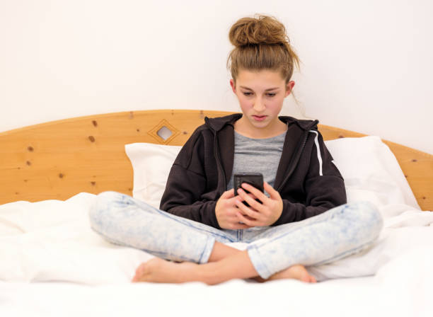 istock Girl in bed with cellphone 1196829085
